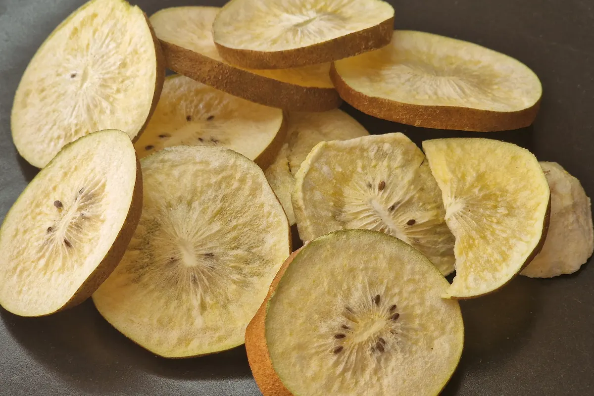 Rodelas de kiwi liofilizado com casca, com as sementes e a estrutura do centro intactas